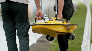 Workers holding the CHCNAV Apache 3 Pro USV Marine Drone